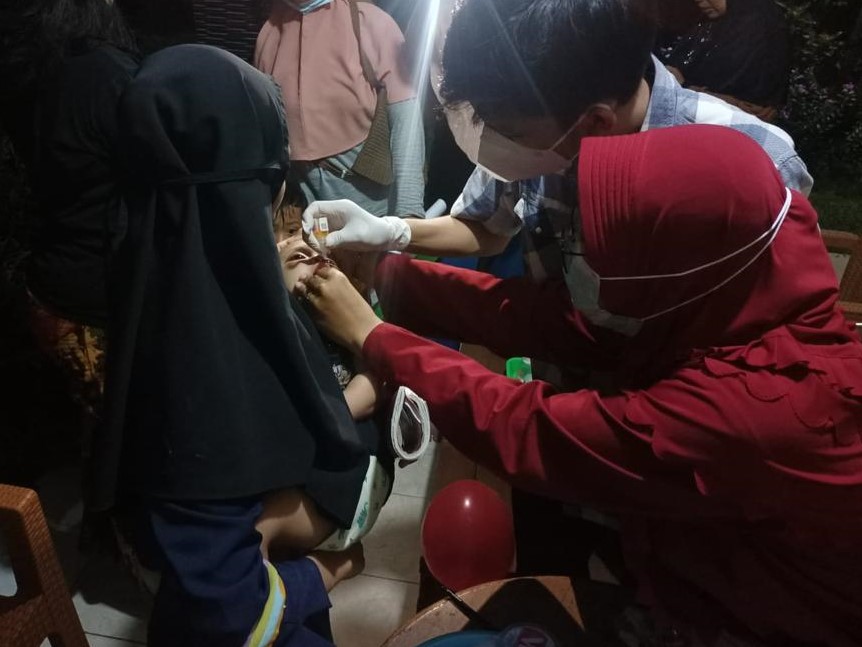 Health care worker vaccinating a child.